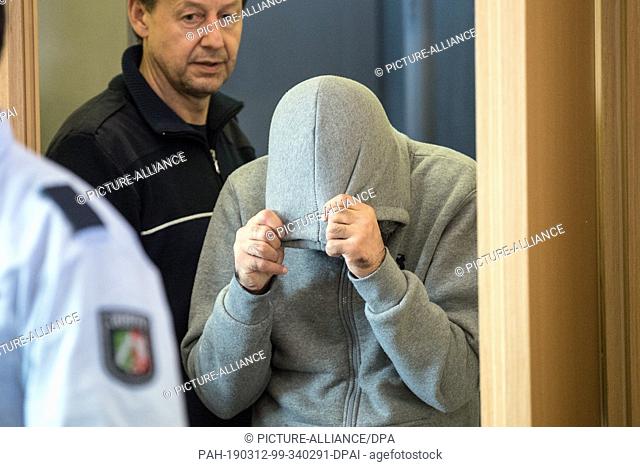 12 March 2019, North Rhine-Westphalia, Düsseldorf: The defendant is taken to the courtroom of the district court. After the murder of a 36-year-old woman from...