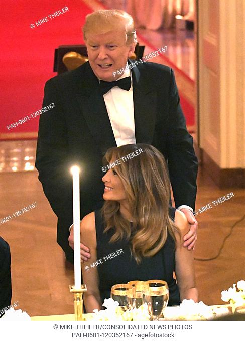 United States President Donald J. Trump shows First Lady Melania Trump to her seat as they attend a White House Historical Association dinner at the White House