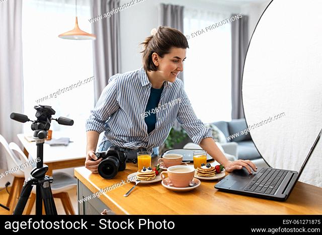 female food photographer with laptop in kitchen