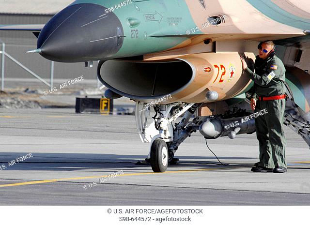 A maintainer from the 64th Aggressor Squadron at Nellis Air Force Base, Nevada, preps an 'enemy' F-16 Fighting Falcon April 10 prior to a mission during Red...