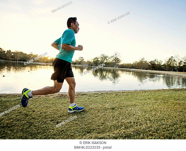 Older Chinese man running in park