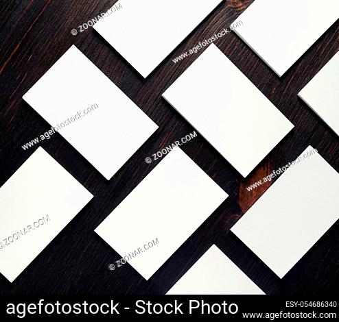 Blank white business cards on wood table background. Mockup for branding identity. Copy space for text. Flat lay
