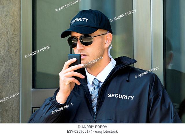 Portrait Of Young Security Guard Using Walkie-talkie Radio