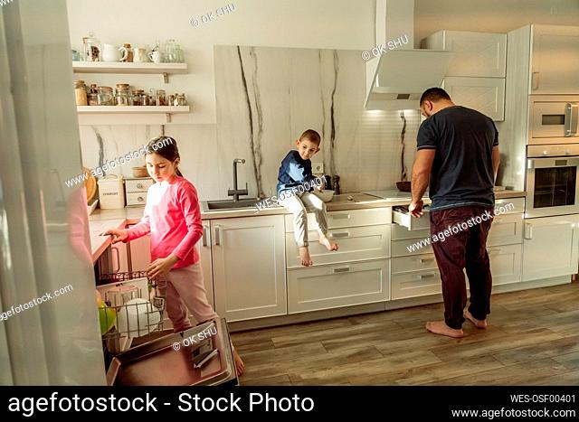 Father with children in kitchen at home