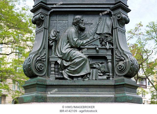 Martin Luther monument, detail, relief, Luther translating the Bible, 1895, by sculptor Adolf von Donndorf, Eisenach, Thuringia, Germany