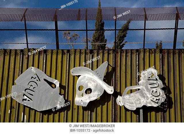 The skull wearing a sombrero with empty water bottles symbolizes the thousands of Mexican migrants who have died trying to illegally cross the border through...