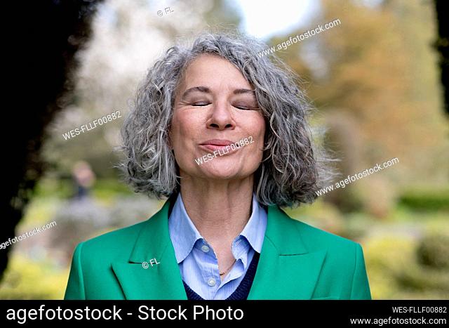 Smiling senior woman with eyes closed enjoying nature