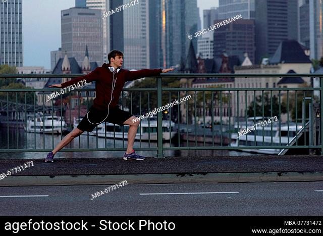 Sporty man stretching in the town, Frankfurt on the Main, Hessen, Germany