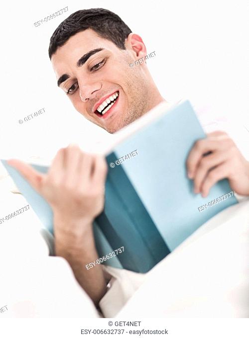 Young man enjoy reading book in bed over white background