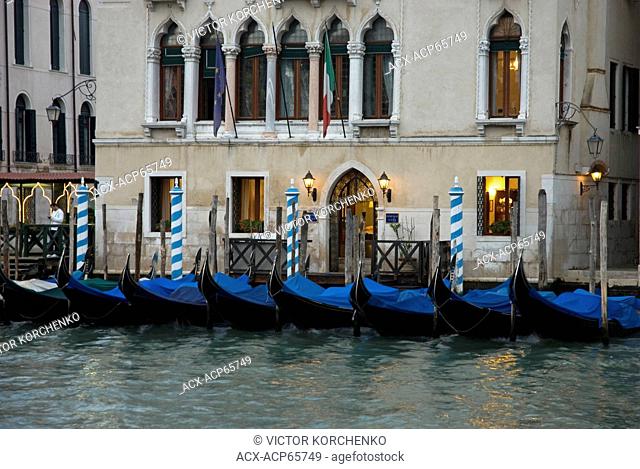 Facade of a building with a dock for boats on Grand Canal in Venice, Italy