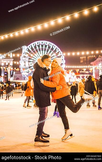 couple hugging in Saint Valentine's Day. Young romantic pair having fun outdoors in winter. St. Valentines Day at city ice rink. New Year holidays