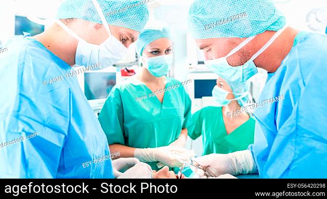 Hospital - surgery team in the operating room or Op of a clinic operating on a patient, perhaps it's an emergency