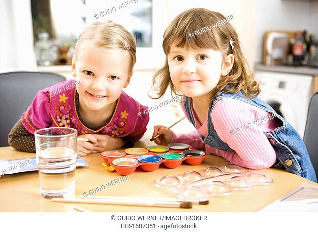 Two girls painting with water colours