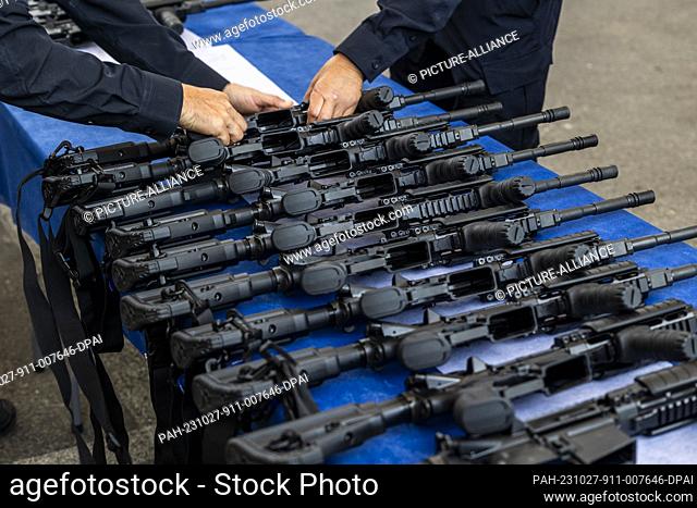 27 October 2023, Israel, Ashkelon: A police officers sorts M5 automatic assault rifles ahead of handing them to members of the new civilian guard unit during an...