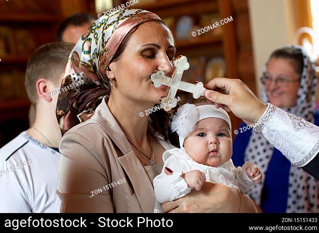 Belarus, the city of Gomel. June 10, 2017. Church at the regional hospital. The baptism of a child.During the baptism of a child, a woman kisses a cross