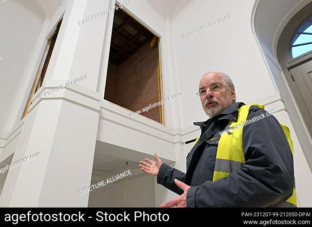 PRODUCTION - 06 December 2023, Brandenburg, Potsdam: Wieland Eschenburg from the Garrison Church Foundation points to the wall openings in the chapel of the...