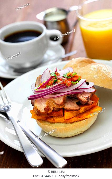 bun with fried pork meat, sweet potato and salsa criolla