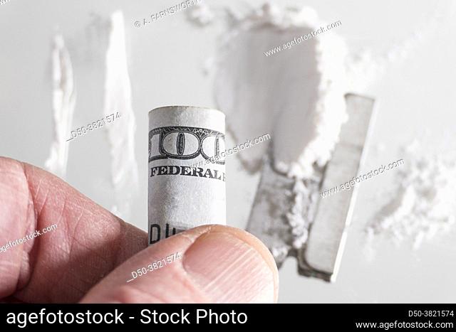 A pile of white drugs witha razor blade and US currency rolled up for snorting