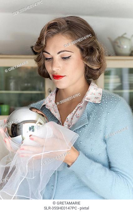 Woman polishing mirrored ball