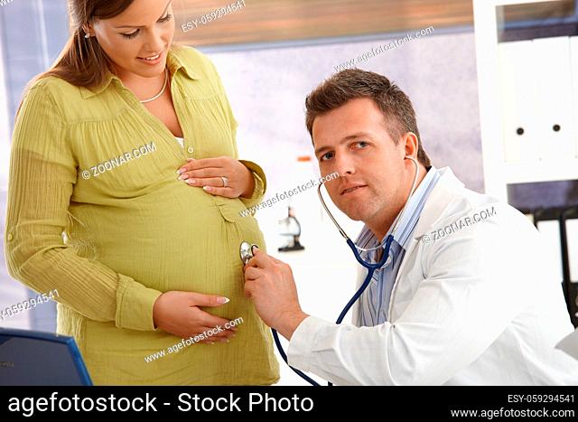 Doctor concentrating on pregnancy examination with stethoscope in consulting room