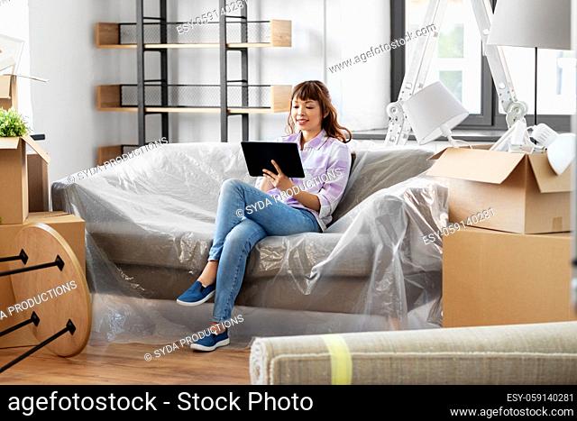 asian woman with tablet pc moving into new home
