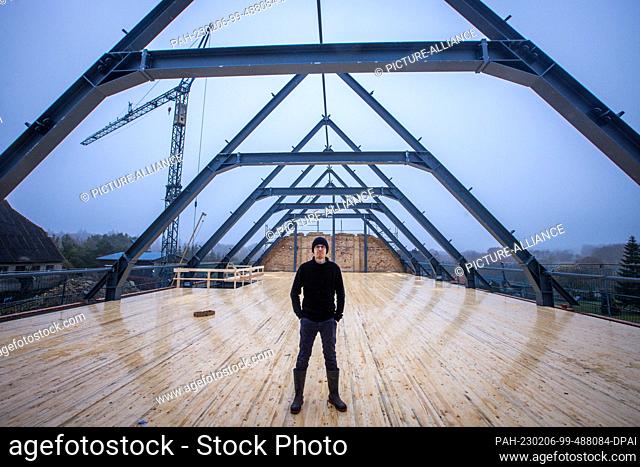 PRODUCTION - 26 January 2023, Mecklenburg-Western Pomerania, Teplitz: Nordwolle founder Marco Scheel stands on the wooden false ceiling in the fieldstone barn