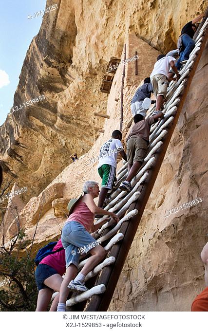 Cortez, Colorado - Visitors climb a ladder to enter the Balcony House cliff dwelling at Mesa Verde National Park  The park features cliff dwellings of ancestral...