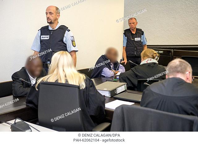 Defendants Straton M. (l) and Ignace M. (4.f.l.) sit next to their lawyers in the dock before sentencing at the higher regional court in Stuttgart, Germany