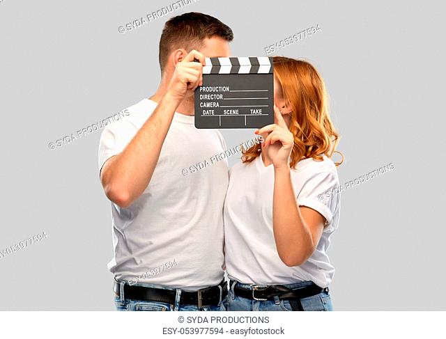 happy couple in white t-shirts with clapperboard