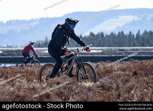 16 April 2022, Hessen, Willingen: Cyclists are on their way to the Ettelsberg with their mountain bikes. The mountain bike season has begun in Willingen in...