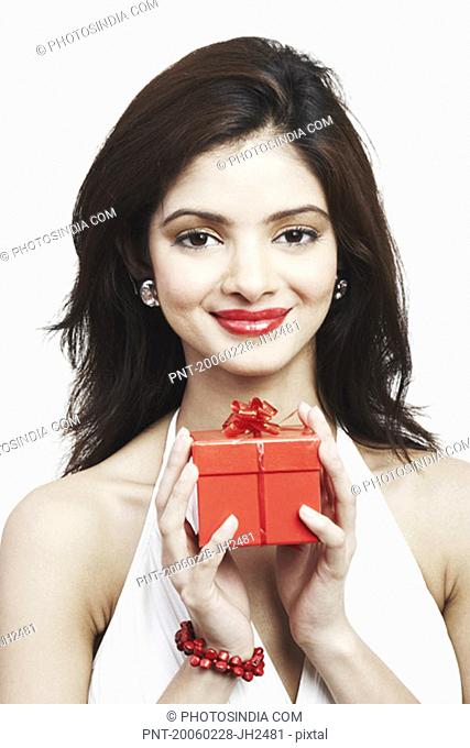 Portrait of a young woman holding a gift box