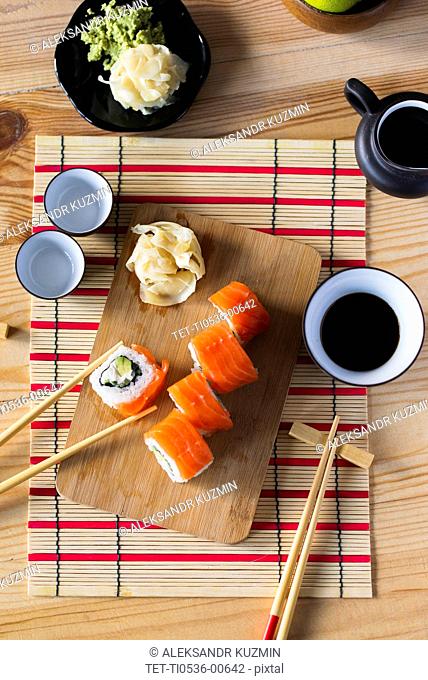 Salmon sushi on cutting board with condiments