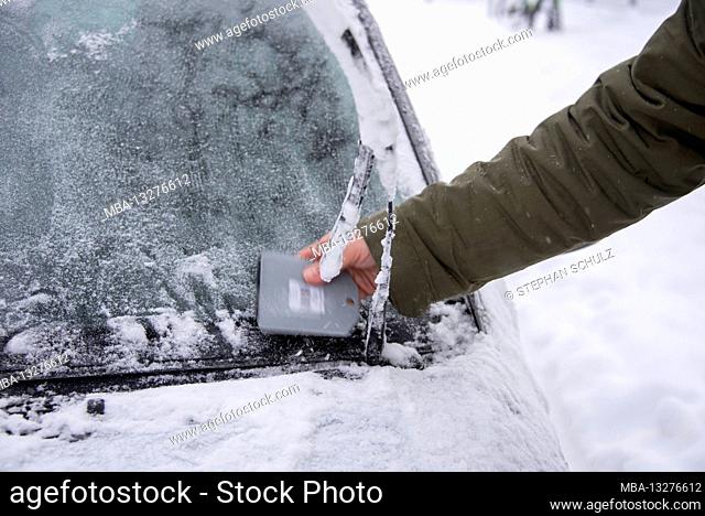 Germany, Saxony-Anhalt, Magdeburg, a man scratches the frozen window of his car free