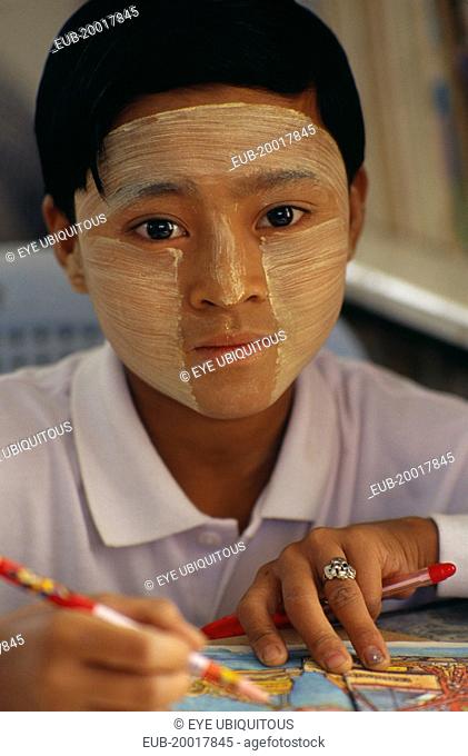 Young girl wearing thanaka paste on her face in traditional Burmese style