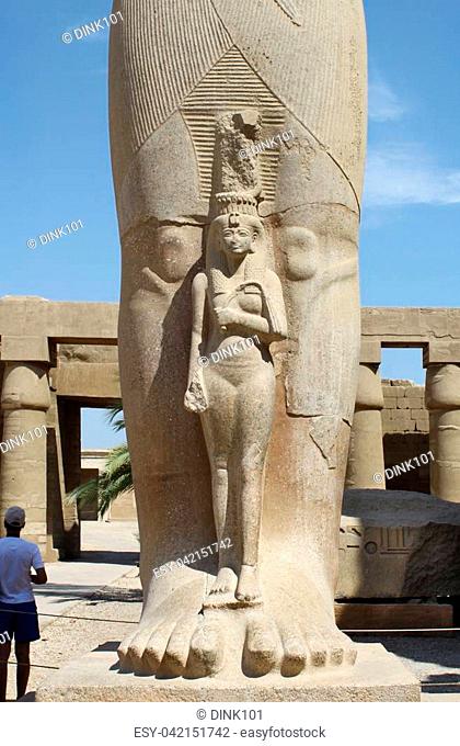 Detail of the statue of Pharaoh Ramses II with the small statue of Queen Nefertari at his feet, Karnak Temple, Luxor, Egypt
