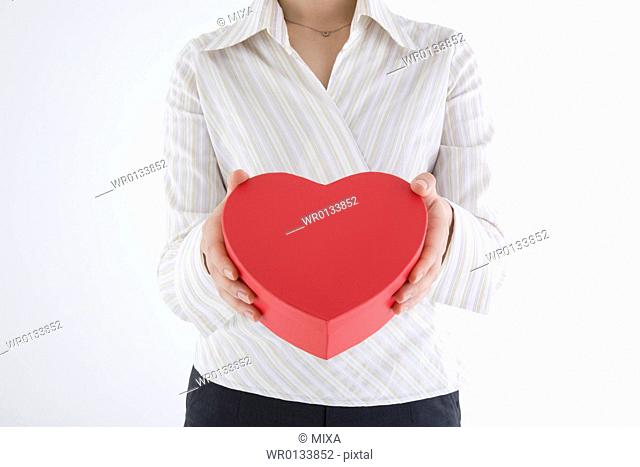 Businesswoman holding heart-shaped box