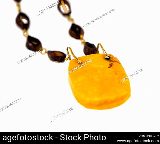 Big amber stone necklace isolated on white background. Closeup of luxury apparel