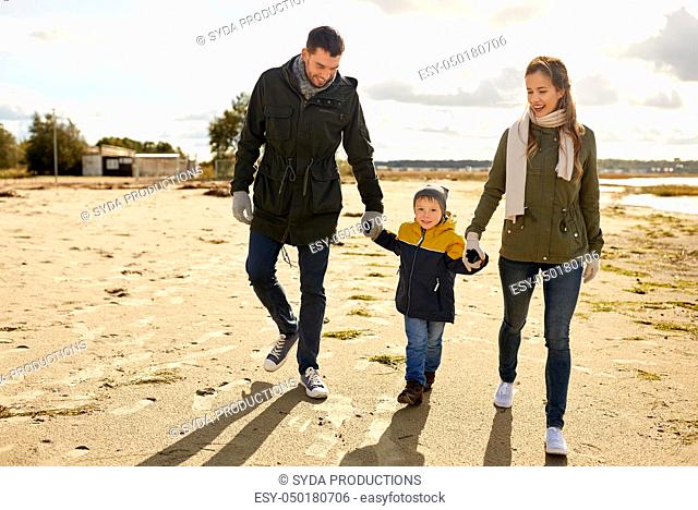 happy family walking along autumn beach