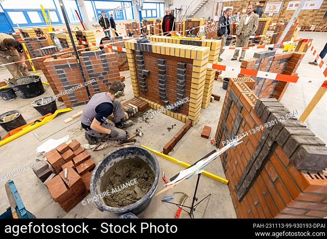 13 November 2023, Thuringia, Erfurt: Bricklayer Johannes Halbach (Thuringia) builds a decorative masonry wall from modules with the lettering ""Erfurt"" at the...