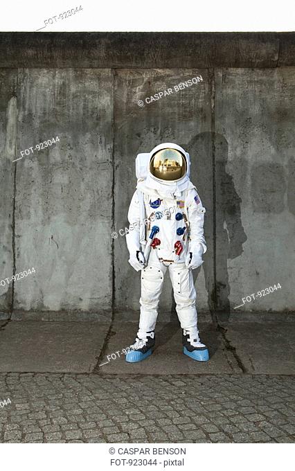 An astronaut standing on a sidewalk in a city