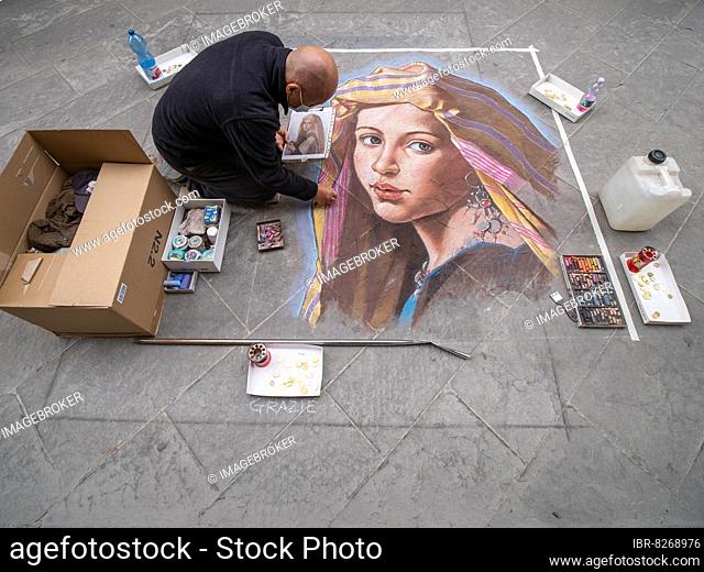Straßenkünstler malt ein Bild mit Kreide auf den Asphalt, Florenz, Italien