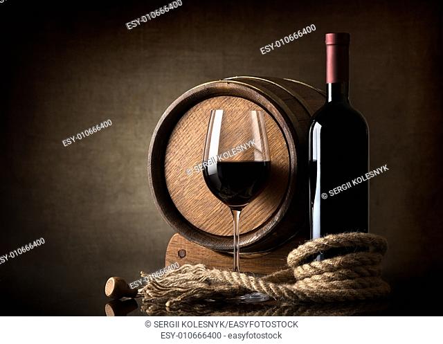 Bottle of red wine, grapes and wooden barrel