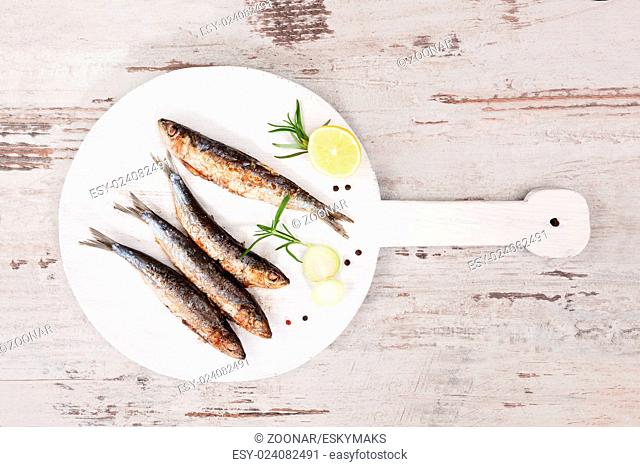 Grilled sardines on wooden plate