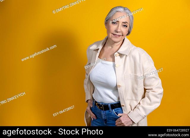 Woman. Good-looking woman in beige standing on yellow background