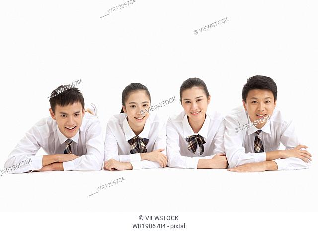Four high school students with arms crossed on the floor