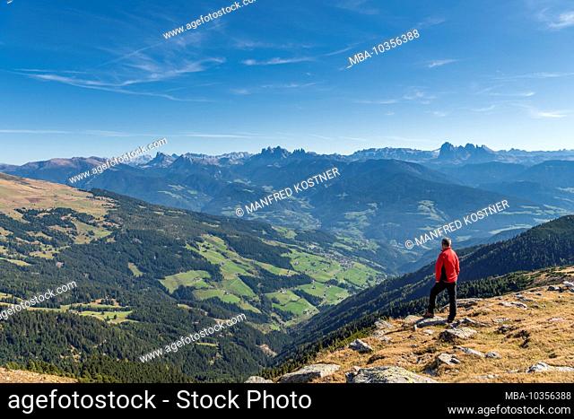Latzfons, Klausen, Bolzano province, South Tyrol, Italy, Europe. A hiker admires the mountain panorama from Jocherer Berg