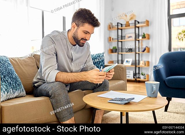 man with money and calculator filling papers