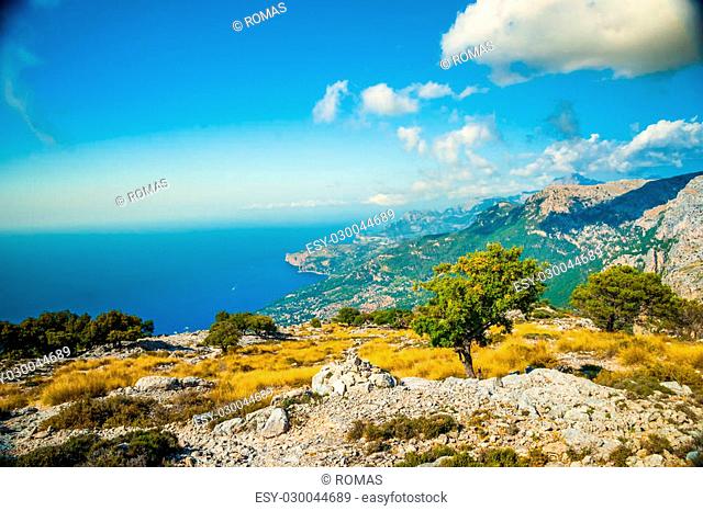 Beautiful landscape with a lane between rocky mountains on the western part of Mallorca island, Spain. Tramuntana mountains with green bushes