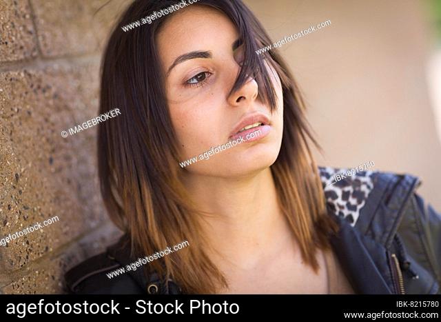 Beautiful meloncholy mixed-race young woman portrait outside