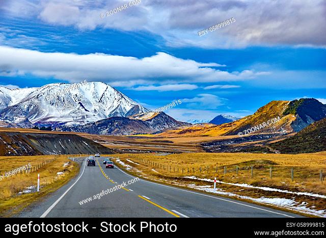 Road trip in winter with snow mountains at background in New Zealand
